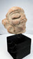 Ancient Mesoamerican figure head with deeply recessed eyes and circular ear ornaments