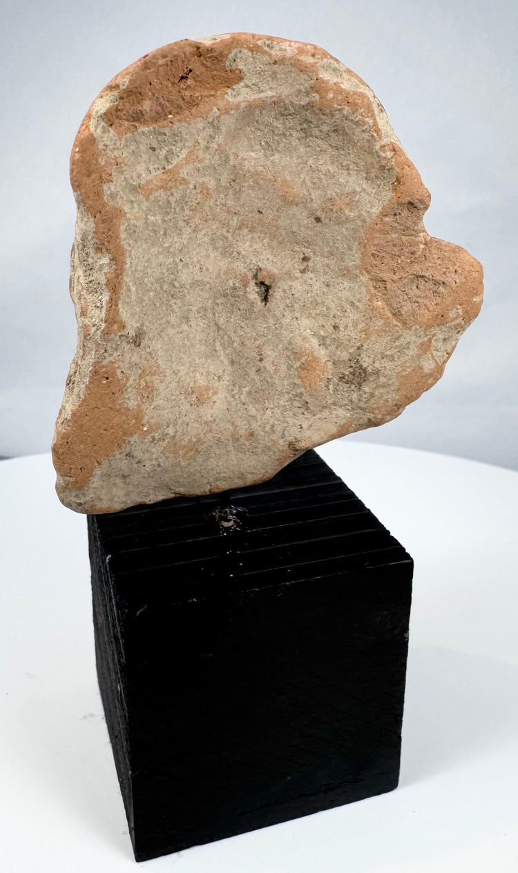 Mesoamerican archaeological terracotta fragment depicting a stylized human face