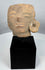 Authentic Pre-Columbian terracotta sculpture fragment from ancient Mesoamerica displayed on a stand.