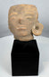 Authentic Pre-Columbian terracotta sculpture fragment from ancient Mesoamerica displayed on a stand.