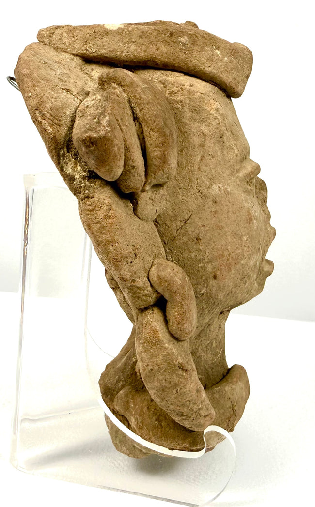 Side profile of ancient Mesoamerican terracotta head displaying headdress structure