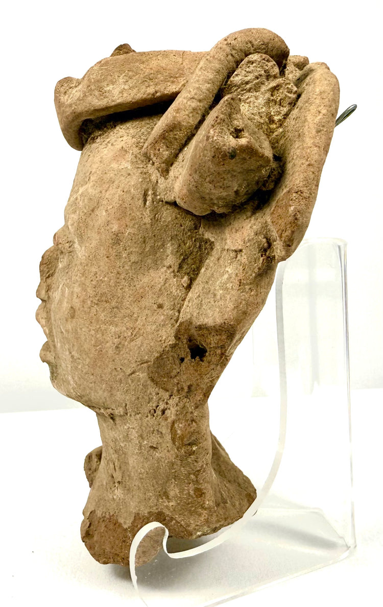 Left profile of Pre-Columbian terracotta head sculpture on acrylic display stand