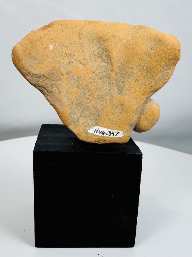 Archaeological terracotta human figure fragment with weathered surface and burial patina.