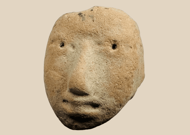 Pre-Columbian terracotta human head fragment with stylized facial features mounted on a custom display stand.