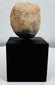 Stylized Pre-Columbian terracotta face fragment mounted for display with visible weathering and age.