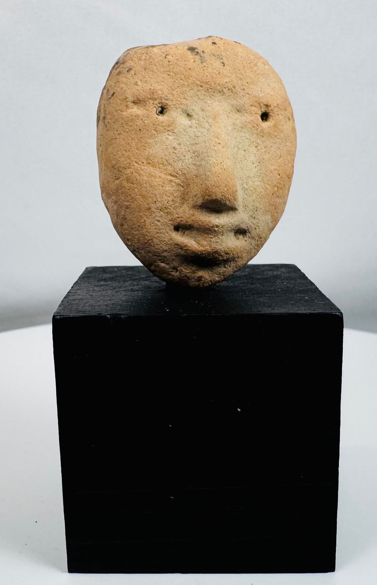 Archaeological terracotta human head fragment originally part of a larger ceremonial vessel or figure.