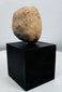 Terracotta human figure fragment featuring perforated eyes and simplified facial modeling.