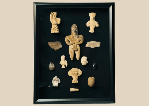 Framed collection of Pre-Columbian terracotta and stone artifacts displayed in a shadowbox.