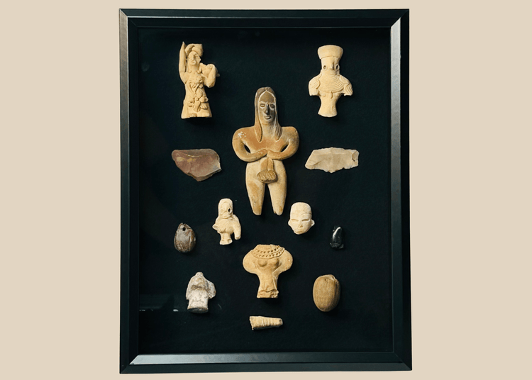 Framed collection of Pre-Columbian terracotta and stone artifacts displayed in a shadowbox.