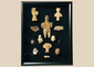 Framed collection of Pre-Columbian terracotta and stone artifacts displayed in a shadowbox.
