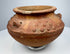 Ancient terracotta ritual vessel from the Americas with molded ornament and compact hand-crafted form.