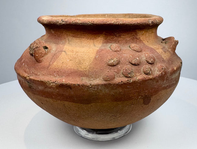 Ancient Central or South American terracotta vessel displaying raised motifs and traditional Pre-Columbian ceramic craftsmanship.