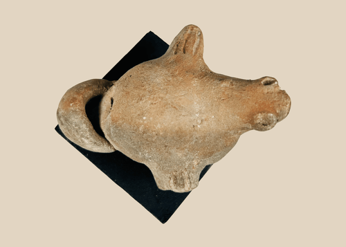 Ancient Pre-Columbian terracotta zoomorphic effigy figure with stylized animal form and ritual opening, mounted on display base