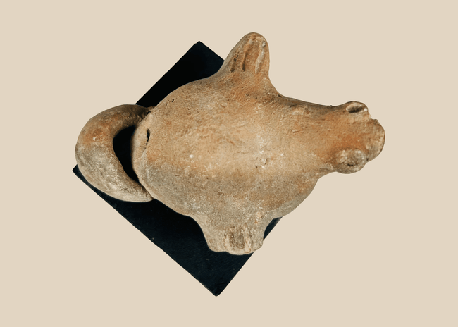 Ancient Pre-Columbian terracotta zoomorphic effigy figure with stylized animal form and ritual opening, mounted on display base