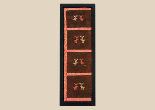 Ancient Pre-Columbian textile fragment featuring geometric animal motifs embroidered in red, gold, and tan thread on a dark brown woven ground, preserved in a protective display frame, dating to circa 1000–1400 CE, representing Andean artistry and symbolic ritual use.