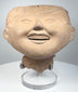 Ancient Mexican smiling face ceramic head from Veracruz with rounded cheeks and gently narrowed eyes
