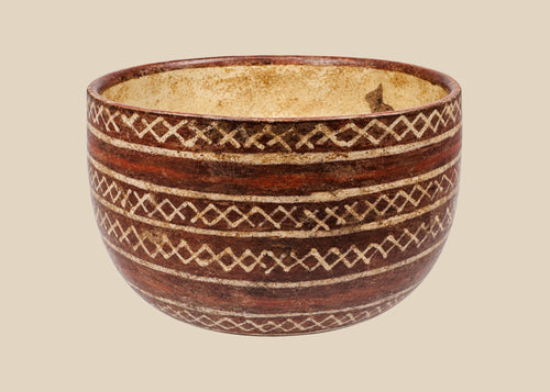 Red-brown ceramic bowl with cream interlocking diamond patterns and horizontal bands