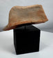 Archaeological terracotta zoomorphic fragment featuring a broad face and expressive stylized features.
