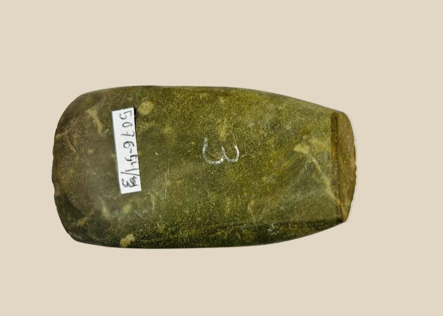 Authentic Pre-Columbian Andean ground-stone axe from Ecuador or Peru, 200–800 AD. Utilitarian tool with fully ground faces, steep beveled cutting edge, and rounded edge from repeated use. Original archaeological tag included. Reflects ancient craftsmanship, daily life, and technological skill of Andean civilizations.