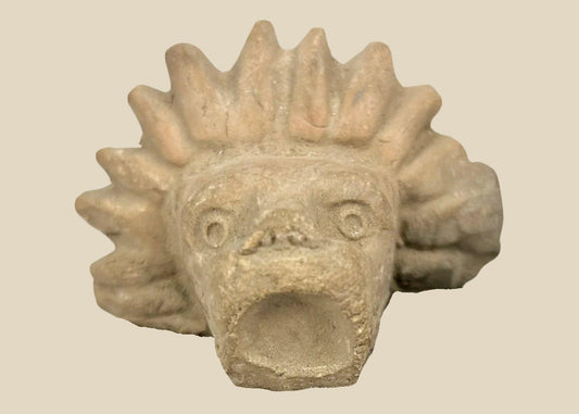 Pre-Columbian Mesoamerican carved stone animal head, circa 900–1500 CE, jaguar or lion-like guardian figure fragment with radiating mane, mounted on black display base