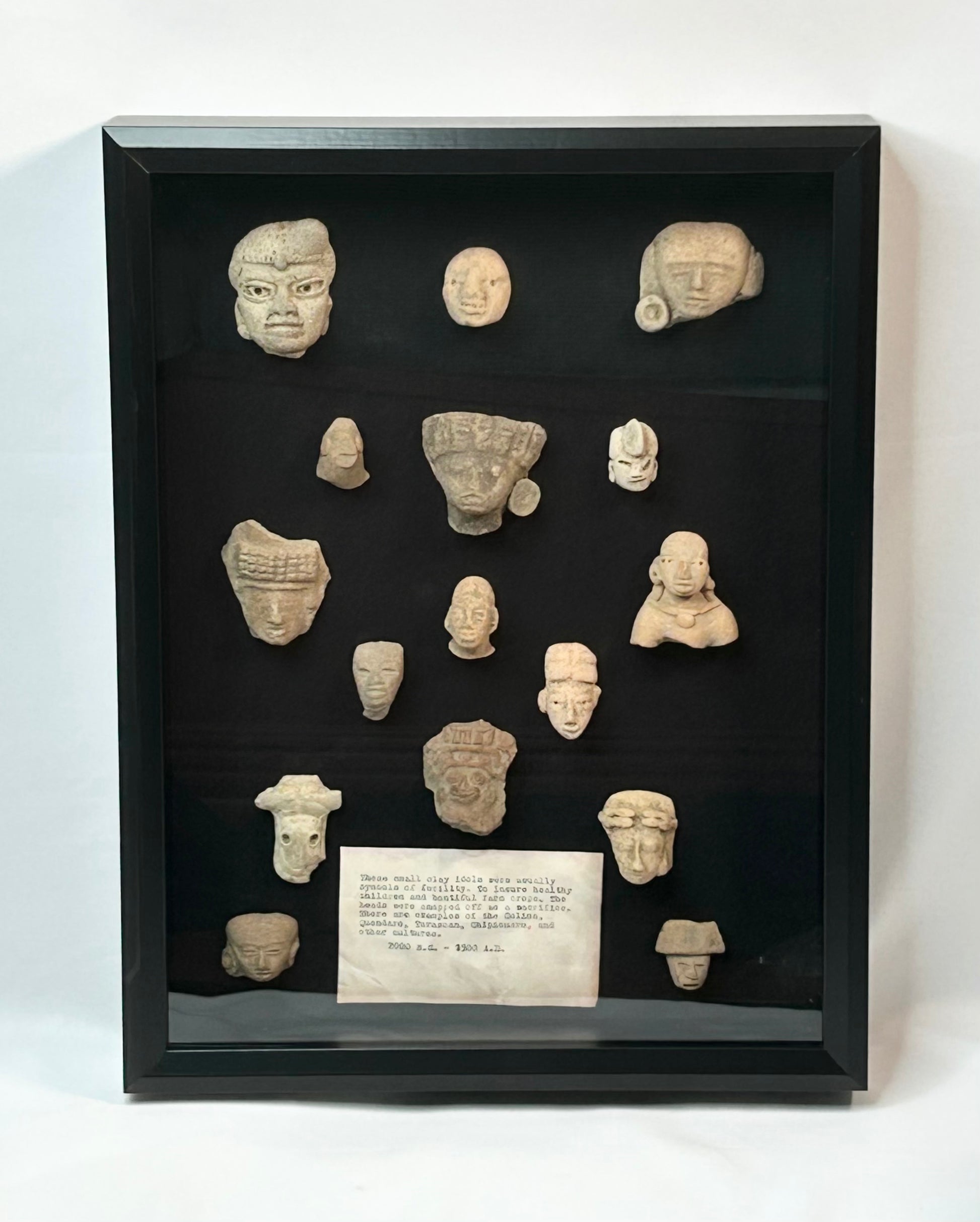 Pre-Columbian Mesoamerican terracotta fragments shadowbox, 16 votive heads, busts, and maskettes from Teotihuacan and Veracruz traditions, 200 BCE–900 CE, archaeological patina