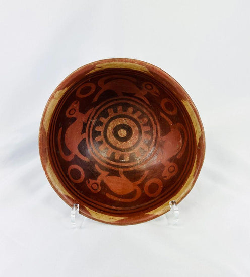 Terracotta Nariño culture bowl from Colombia and Ecuador, decorated with bichrome slip, negative resist geometric border, and four monkeys in the interior, dating from 800–1500 CE.