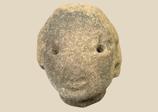 Small Pre-Columbian terracotta head fragment with drilled eyes, rounded features, and subtle mouth, mounted on a black display stand, from West Mexico (Nayarit or Jalisco), circa 300 BCE–300 CE