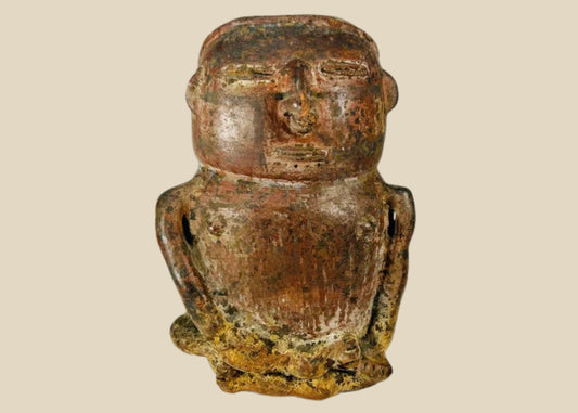 A Pre-Columbian terracotta effigy vessel depicting a seated human figure with stylized facial features, hands on lap, and an opening at the top of the head for offerings, dating to circa 500 BCE–900 CE.