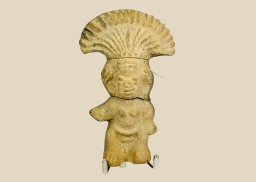 Ancient Pre-Columbian terracotta figurine depicting a standing figure with a wide fan-shaped headdress, stylized facial features, and rounded body, handmade from earthen clay, dating between 500–1500 CE, representing ceremonial or ritual iconography of Mesoamerican cultures.