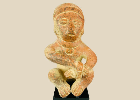 Pre-Columbian seated terracotta figure from West Mexico (Nayarit/Jalisco), circa 300 BCE–300 CE, hand-molded with red slip, stylized anthropomorphic features, burnished surface, shaft tomb funerary artifact on black display stand