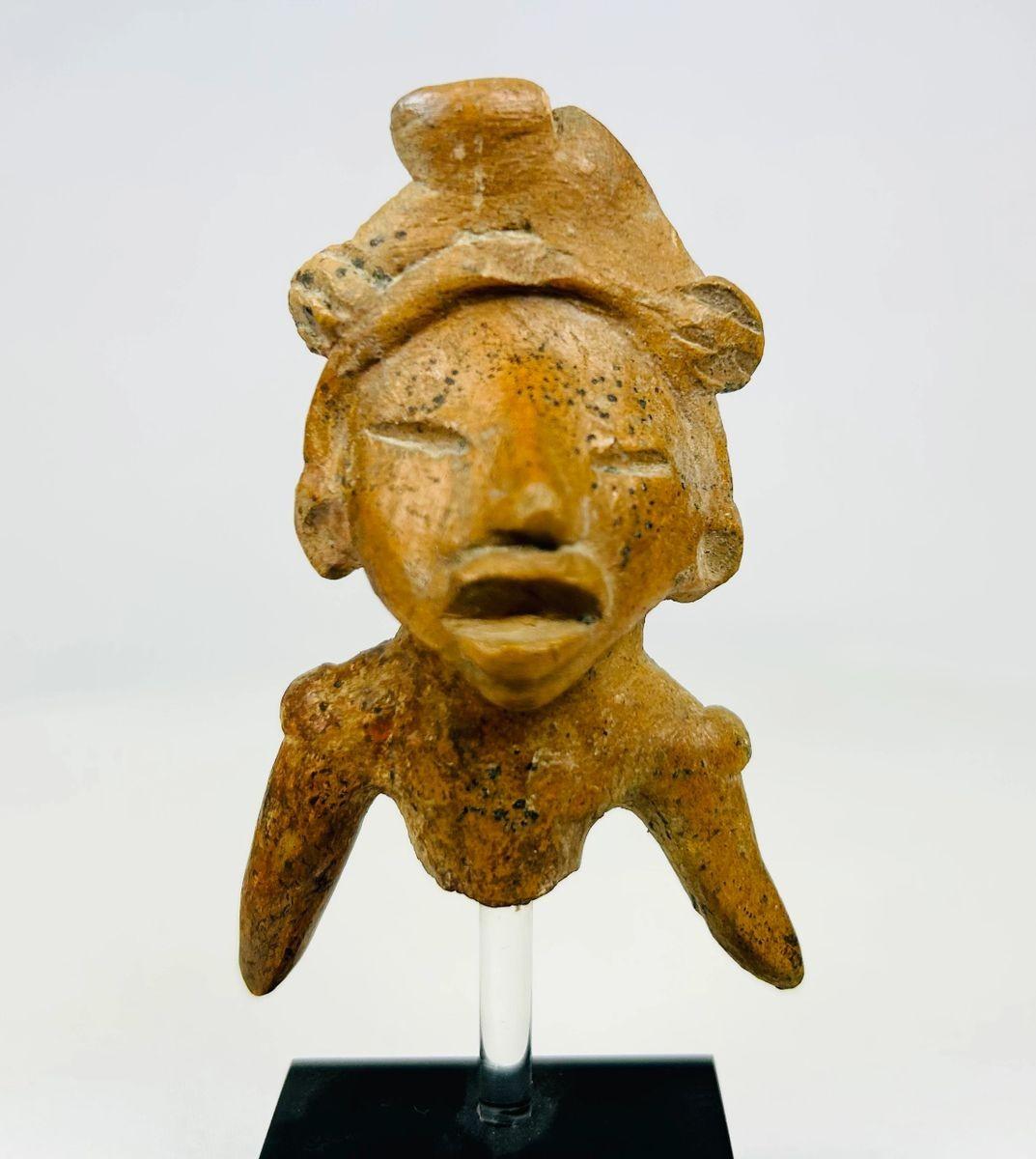 Ancient West Mexican terracotta figure fragment with headdress and expressive open mouth, dating 300 BCE–300 CE, mounted on a museum-style display stand.