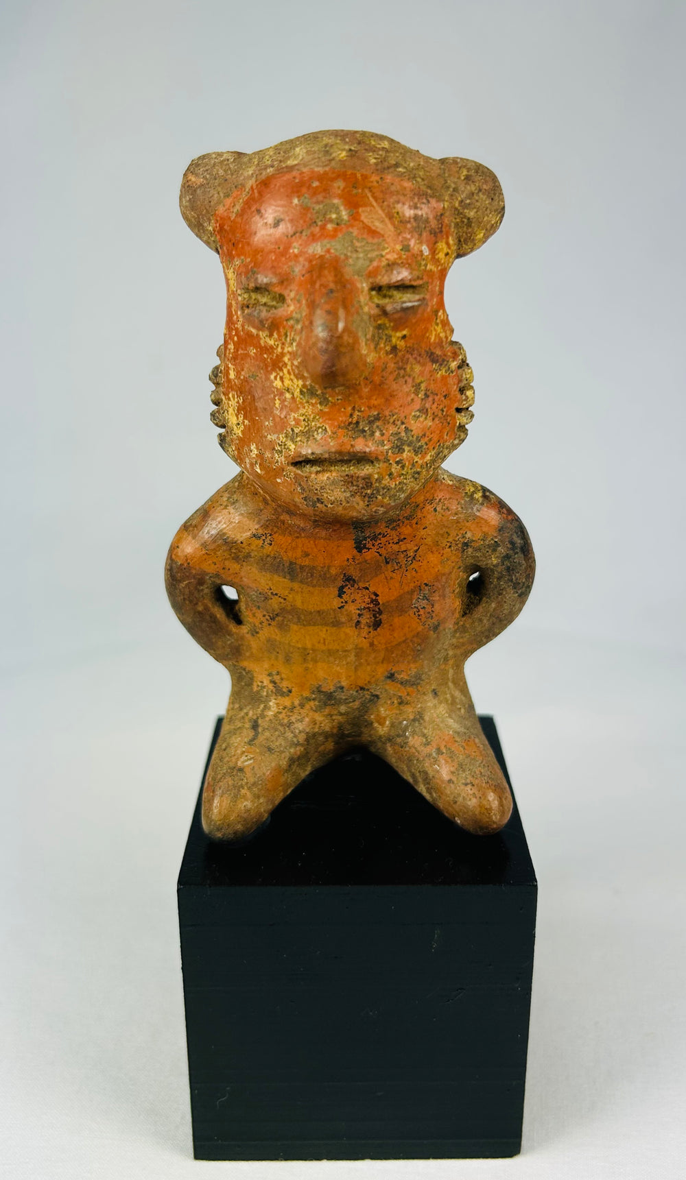 Pre-Columbian West Mexican terracotta figure, circa 300 BCE–500 CE, hand-modeled with stylized features and faint red-orange pigment, Nayarit, Colima, or Jalisco shaft tomb culture, mounted on display base