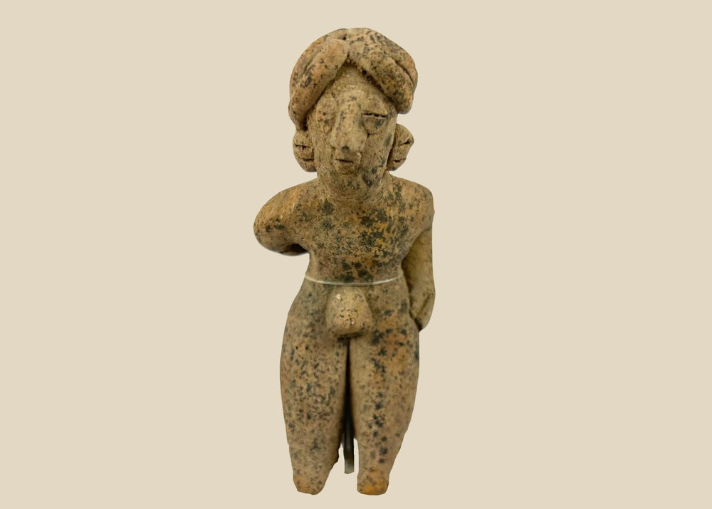 Pre-Columbian West Mexican terracotta standing figure, circa 300 BCE–500 CE, hand-modeled with tall turban-style headdress, stylized proportions, and surface encrustations, mounted on acrylic display base
