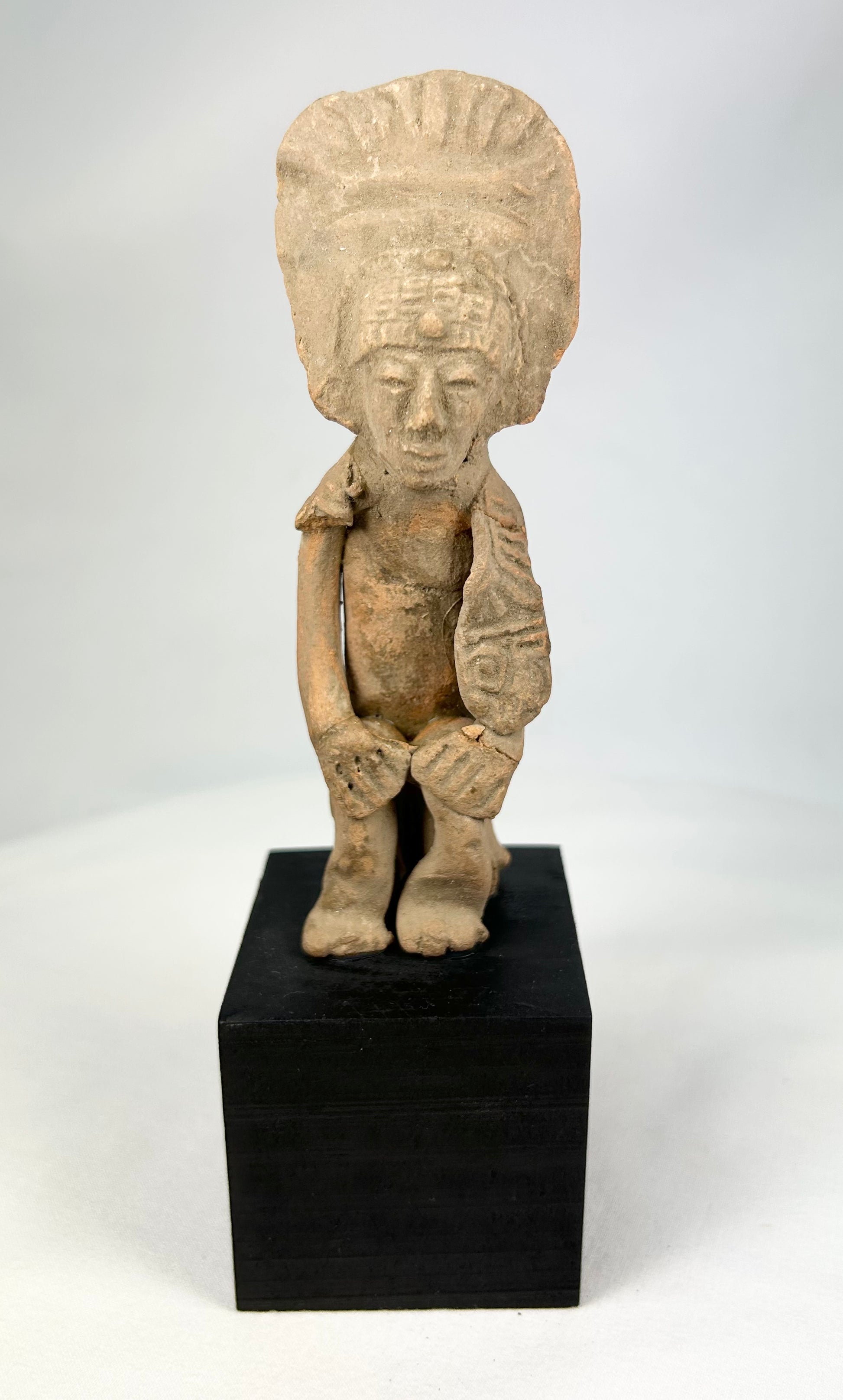 Pre-Columbian West Mexican terracotta standing figure, 300 BCE–500 CE, Nayarit or Jalisco shaft tomb culture, with tall radiating headdress, abstract geometric features, and mineral accretions, mounted on display base