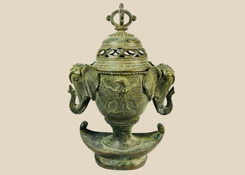 Antique Qing Dynasty bronze incense burner, circa 18th–19th century, with elephant-head handles, phoenix motifs, pierced domed lid crowned by a vajra finial, and crescent-shaped base, retaining traces of gilding and natural verdigris patina.