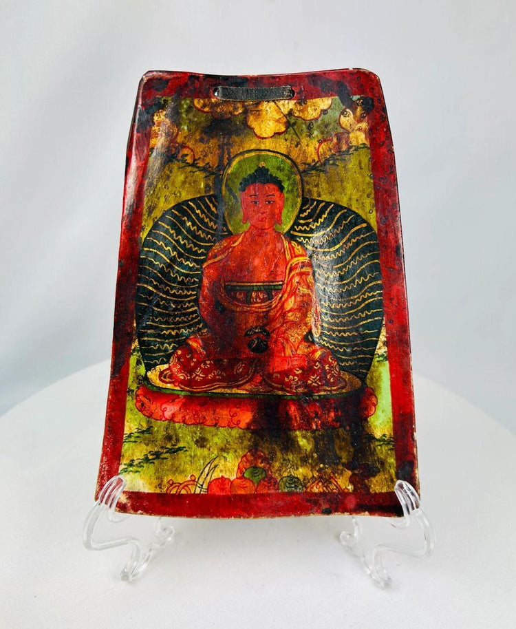 Antique Qing Dynasty Tibetan bone plaque, vividly painted with a seated Buddha in red and gold polychrome, framed by radiant aureole and floral motifs; portable devotional amulet used in Buddhist ritual practice, exhibiting aged surface wear and patina consistent with 19th century craftsmanship.
