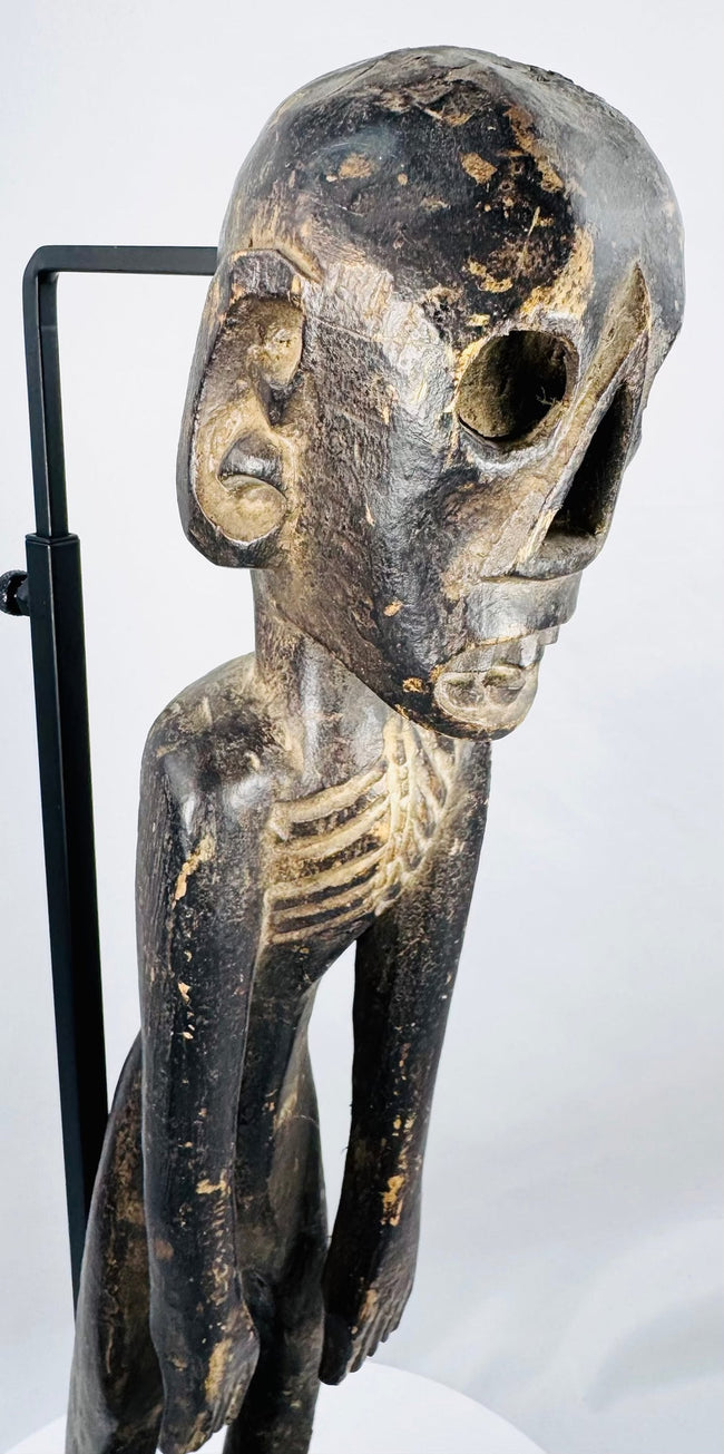 Close-up of Rapa Nui-style wooden figure showing recessed eyes, nose and carved teeth