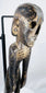 Close-up of Rapa Nui-style wooden figure showing recessed eyes, nose and carved teeth