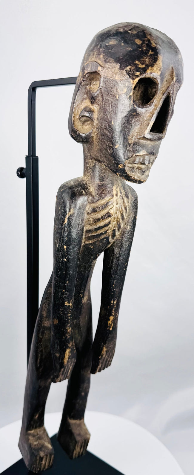 Three-quarter view of hand-carved Rapa Nui-inspired figure with dark aged surface