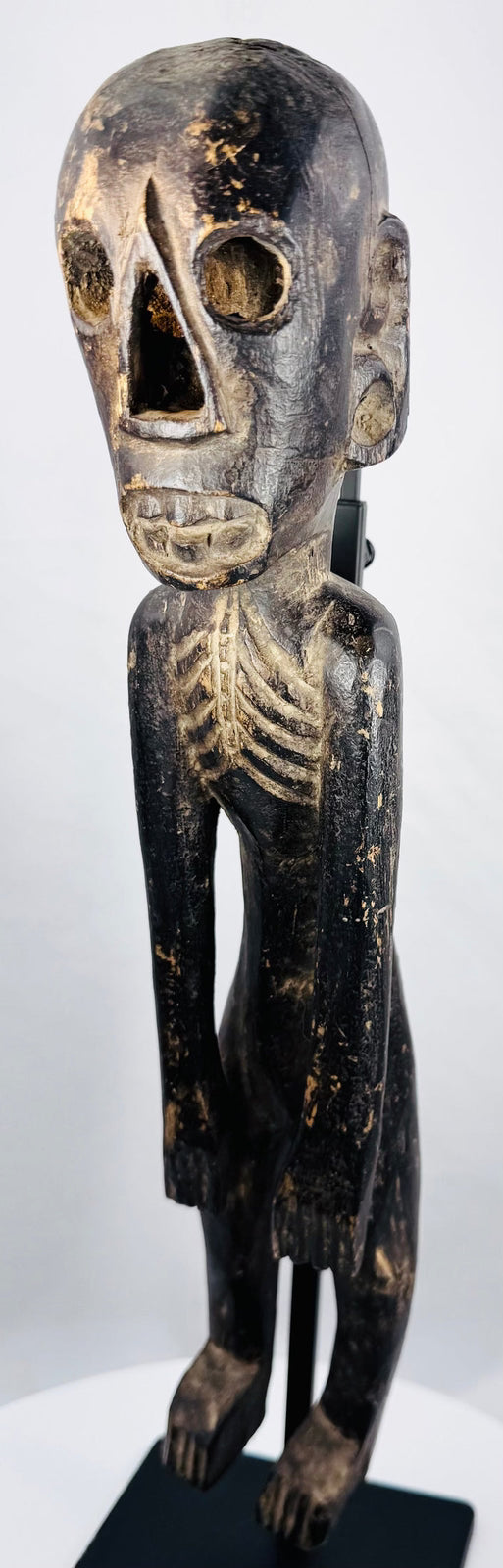 Detailed view of carved skeletal torso and rib cage on Rapa Nui-inspired wooden figure
