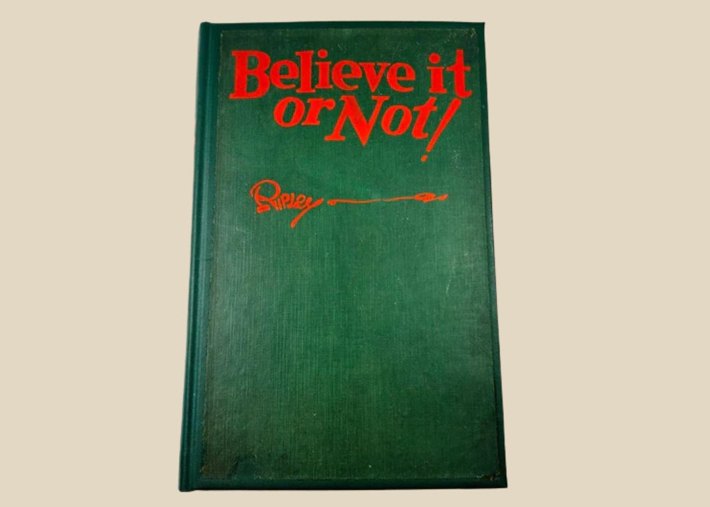 Close-up of 1929 Ripley’s Believe It or Not! signed first edition, showing author inscription and vintage green cloth hardcover.