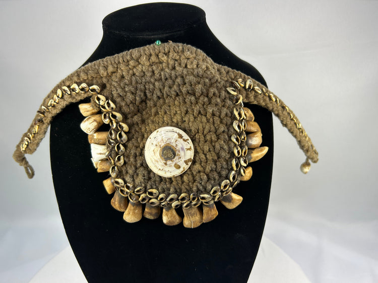 Melanesian ritual adornment featuring cowrie shell and pierced animal teeth