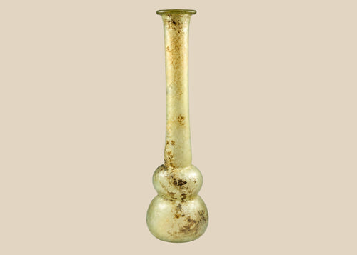 Ancient Roman clear glass double gourd balsamarium from the Eastern Mediterranean, 2nd–3rd Century CE. Features two globular sections joined by a slender neck, naturally iridescent patina, and substantial size for holding perfumes or balms. Reflects Roman glassmaking sophistication, luxury, and daily bathhouse culture.