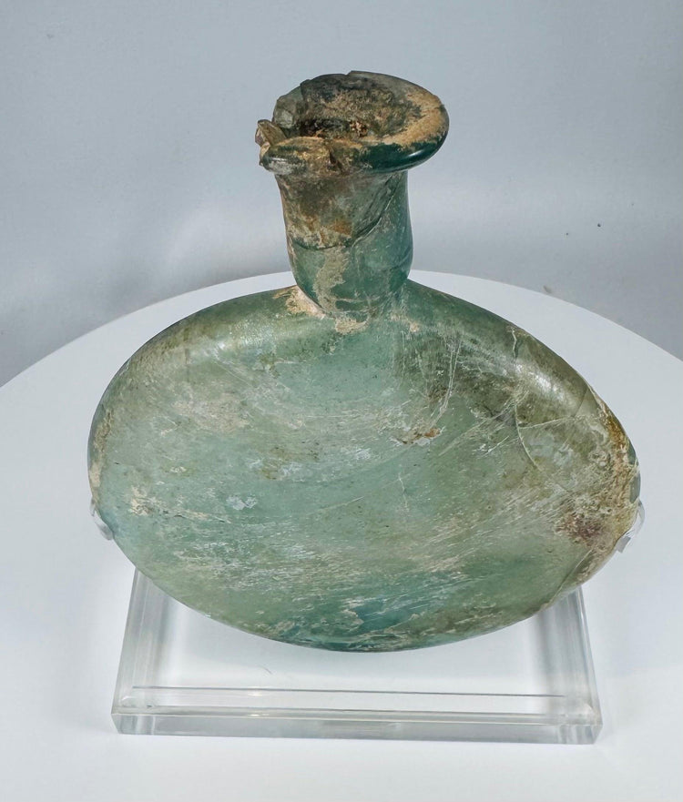 Ancient Roman cosmetic flask mounted on acrylic stand with authentic age-related weathering