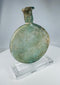 Ancient Roman translucent green glass vessel with weathered surface and elongated neck