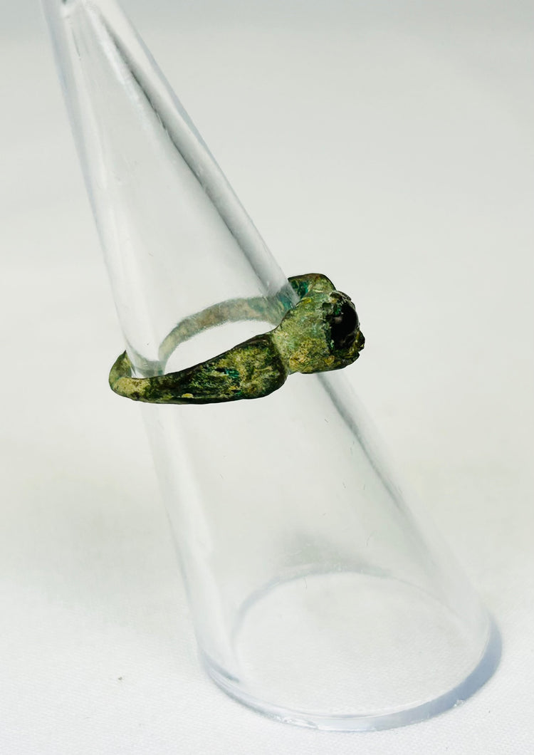Historic Roman bronze ring relic photographed against neutral background