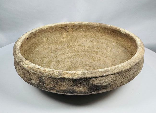 Ancient Roman earthenware bowl from Tunisia with thickened rim, raised central boss, and archaeological mineral deposits.