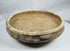 Ancient Roman earthenware bowl from Tunisia with thickened rim, raised central boss, and archaeological mineral deposits.