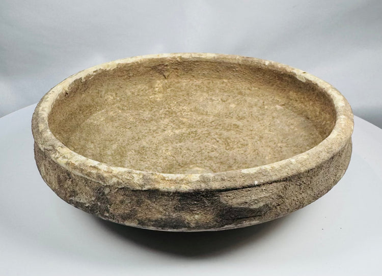 Ancient Roman earthenware bowl from Tunisia with thickened rim, raised central boss, and archaeological mineral deposits.