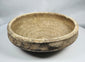 Ancient Roman earthenware bowl from Tunisia with thickened rim, raised central boss, and archaeological mineral deposits.